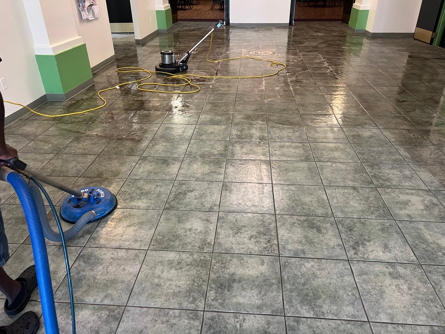 Commercial tile floor being cleaned with a Hydro-Force surface cleaner and floor buffer machine