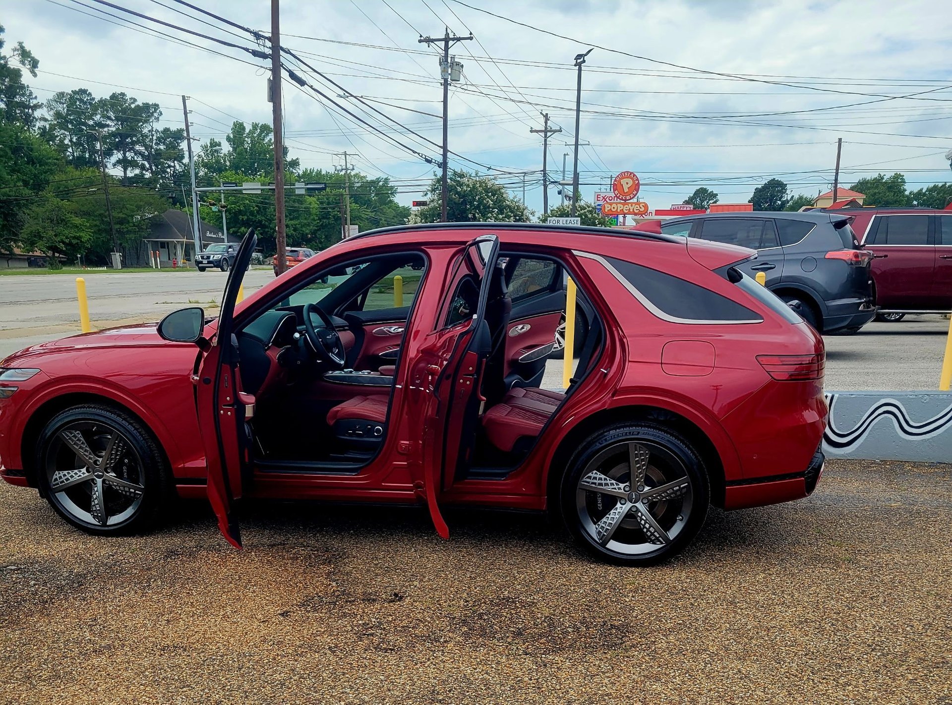Red Genesis SUV with doors open showing a freshly detailed red leather interior at the E Smooth lot