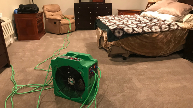 Heater running mid-cycle in a bedroom with cords across the carpet