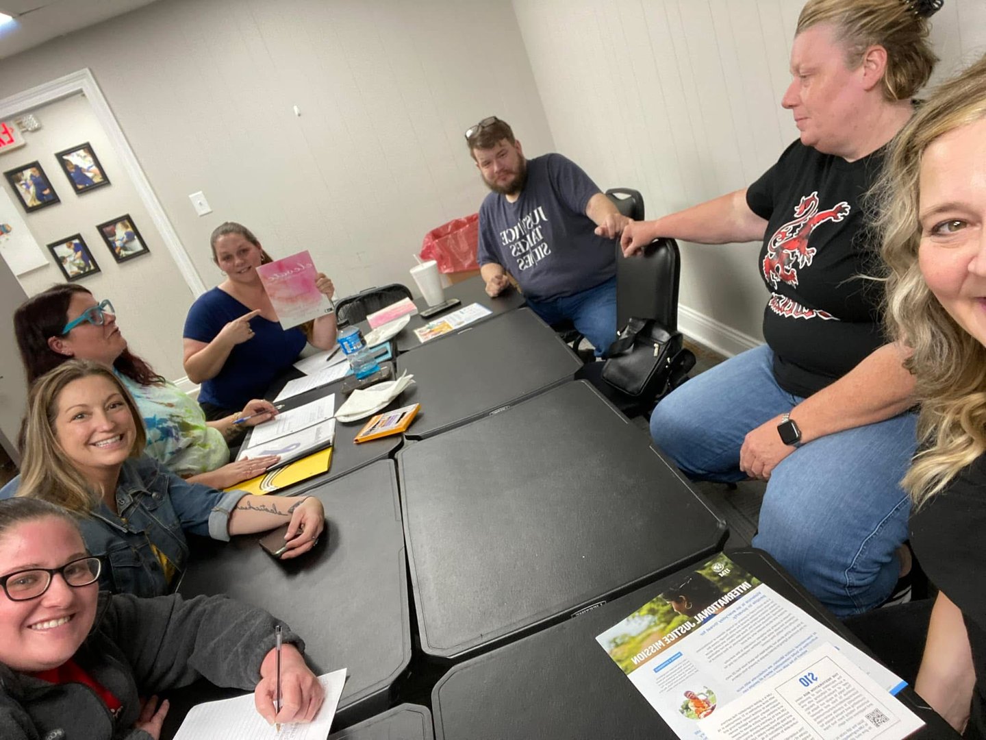 SWLA Abolitionists volunteers gathered around tables with IJM brochures and notebooks during a meeting